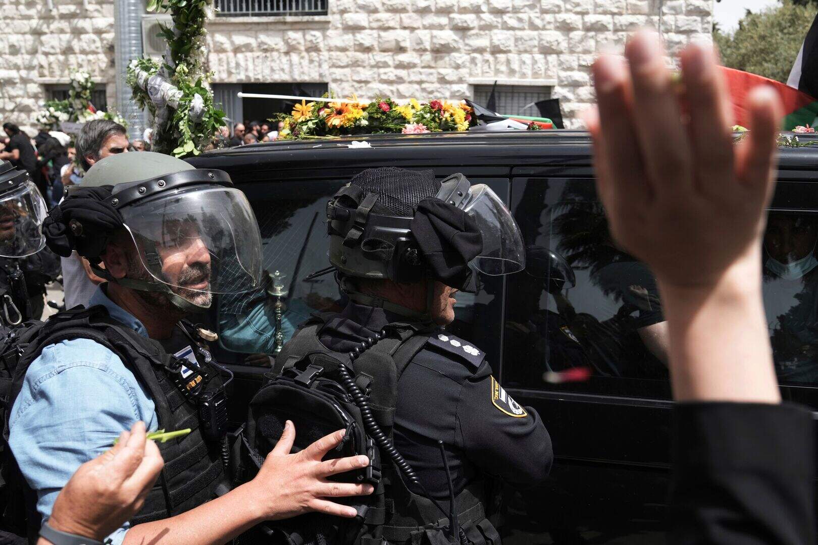 Coffin is dropped amid scuffles before Al Jazeera journalist is laid to ...