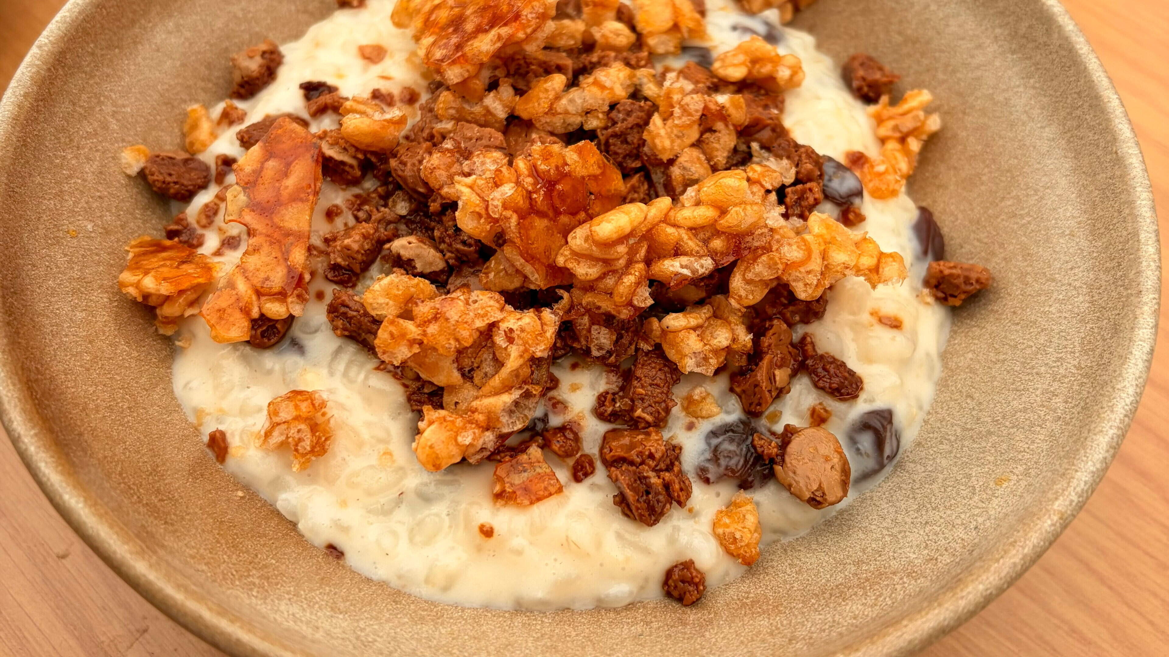 Rum and raisin rice pudding with candied puffed rice