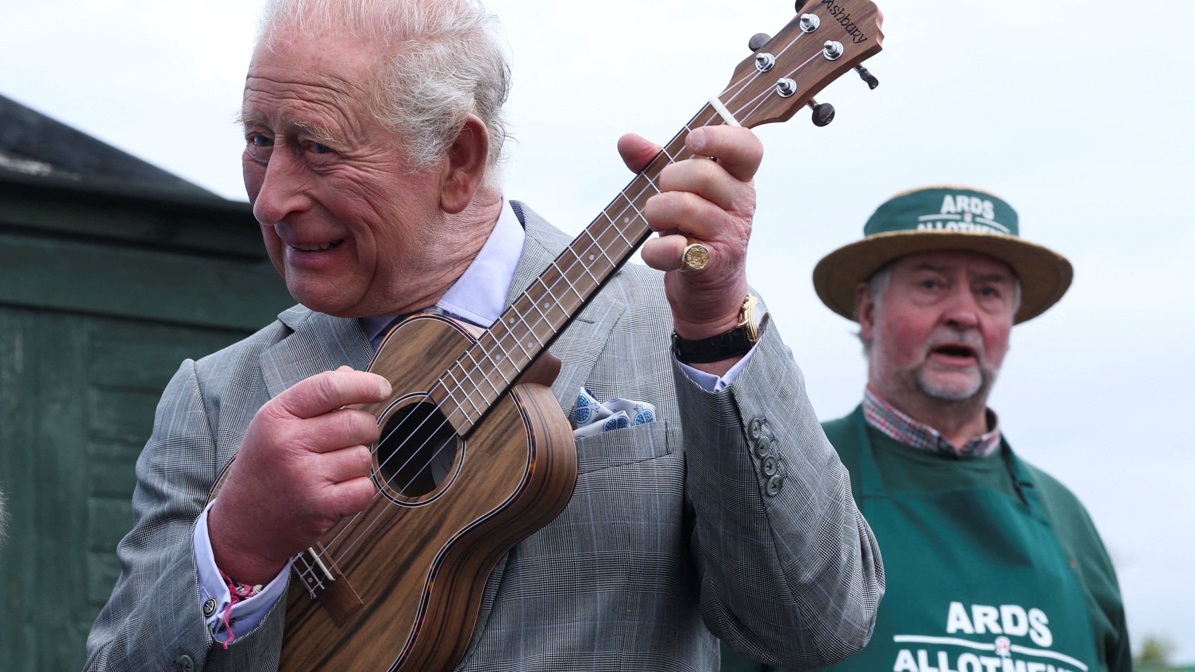 Charles plays ukulele with band during Northern Ireland allotment visit