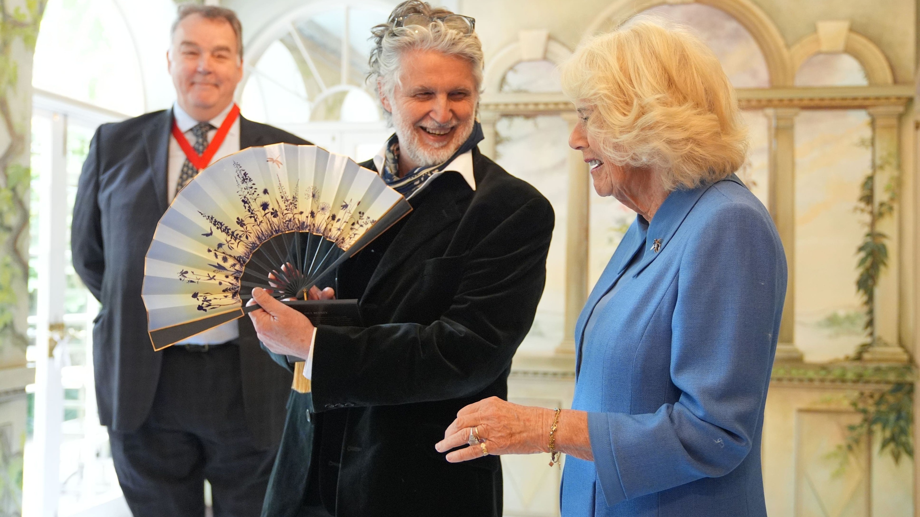 Camilla given fan from coronation portrait on visit to museum’s new exhibition