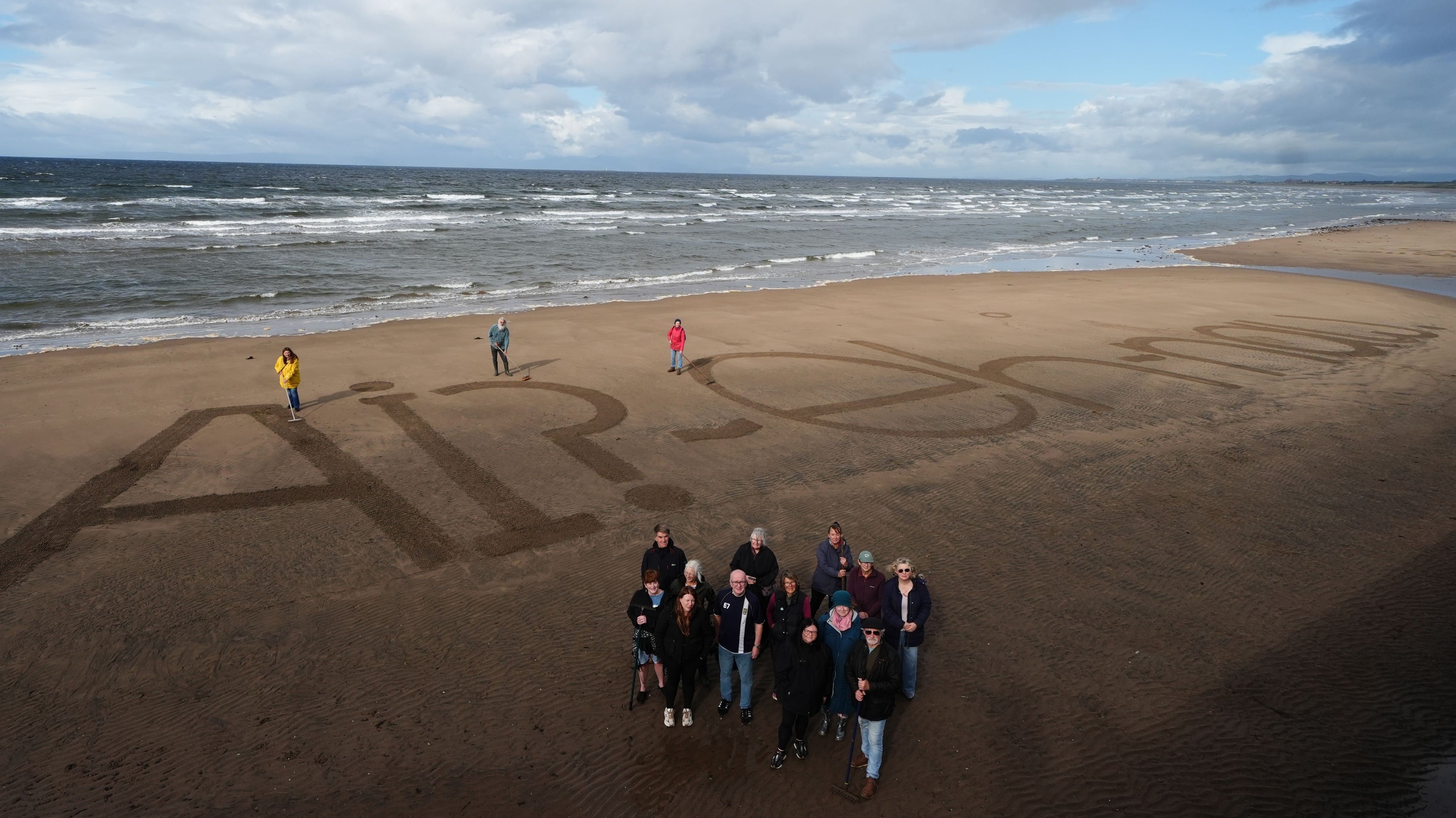 Activists write “naw” to AI on beach ahead of AI summit with King Charles